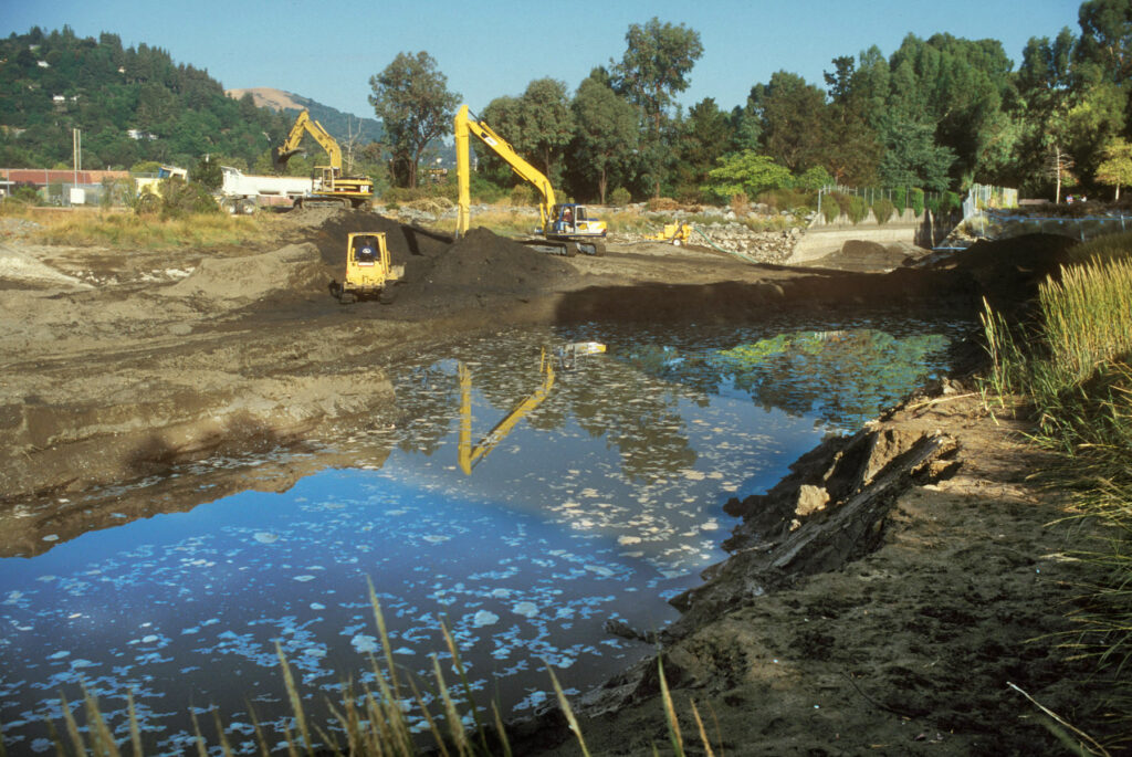 Dredging of sediment at the lower end of the concrete channel, done to increase creek capacity. Tamalpais Creek also joins the widened Corte Madera Creek here.