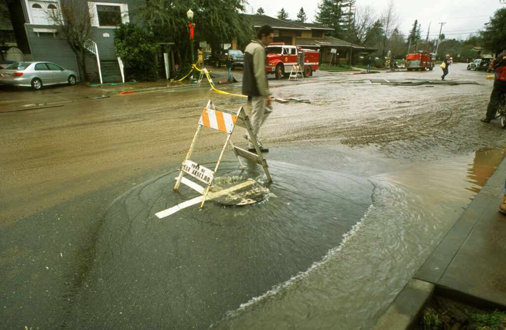 Polluted water gushes from a sewer cover during a storm in downtown San Anselmo